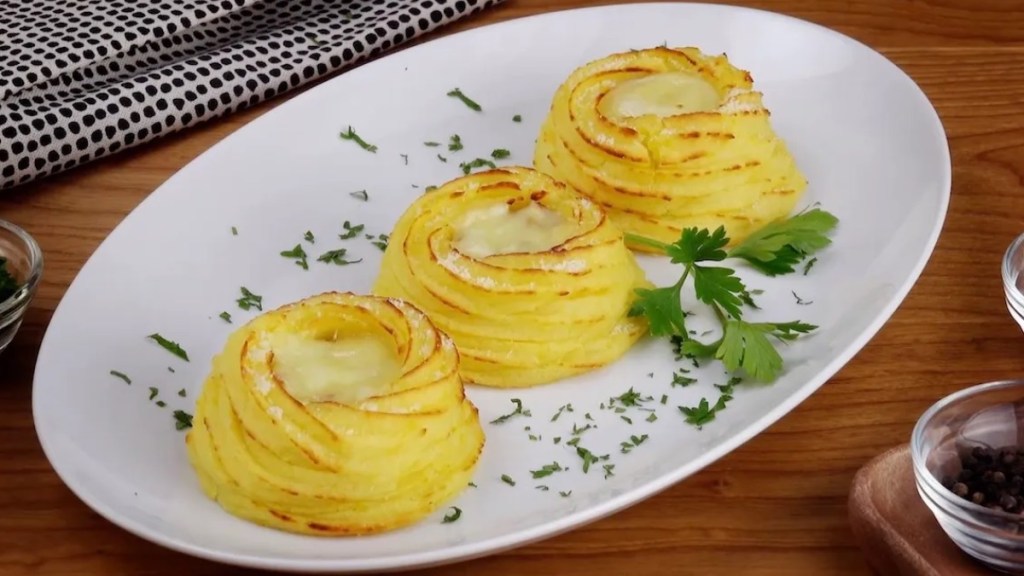 3 Kartoffelnester auf einem Teller mit Petersilie.