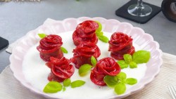 Mehrere Rote-Bete-Rosen aus Nudelteig auf einem weißen Teller.