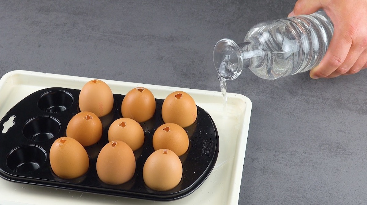 Muffinform mit Eiern wird auf Backblech gestellt, welches mit Wasser gefÃ¼llt wird