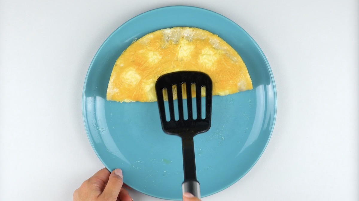 Omelett auf Teller wird in der Mitte zusammengeklappt