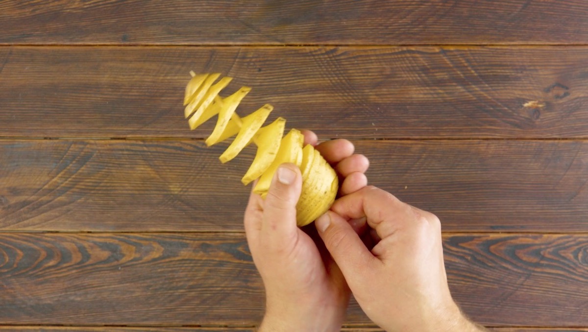 Zu Spirale geschnittene Kartoffel wird auf HolzspieÃŸ aufgespeiÃŸt