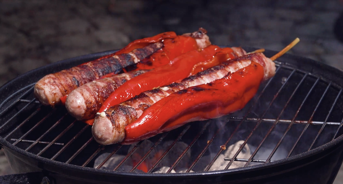 Spitzpaprika wird um BratwÃ¼rste gelegt und gegrillt