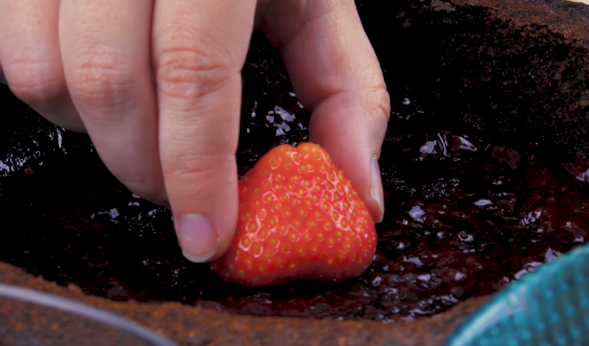 Der Grund des Bodens wird mit Erdbeermarmelade bestrichen und mit frischen Erdbeeren belegt