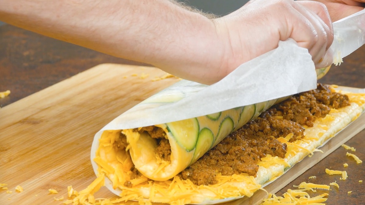 Zucchini-Hackfleisch-Rolle wird vorsichtig eingerollt