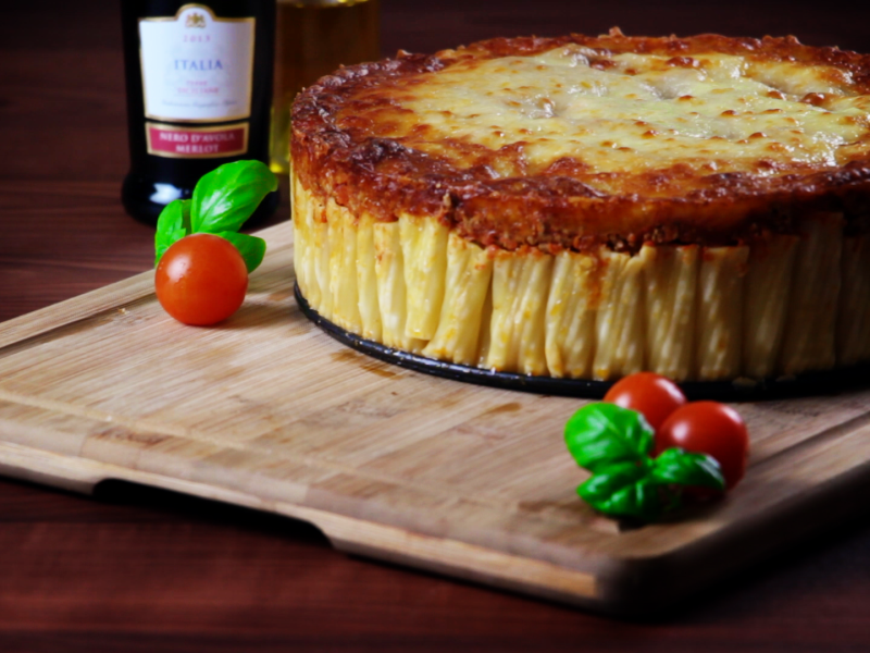 Pasta-Kuchen mit Bolognese auf einem Brett