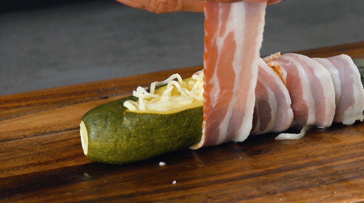 Mit Mozzarella gefüllte Zucchini werden mit Schinken umwickelt