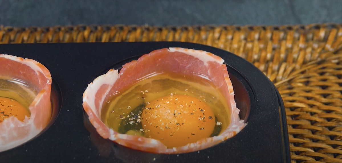 Bacon wird in Innenseite einer Muffinform gelegt und ein Ei darin platziert