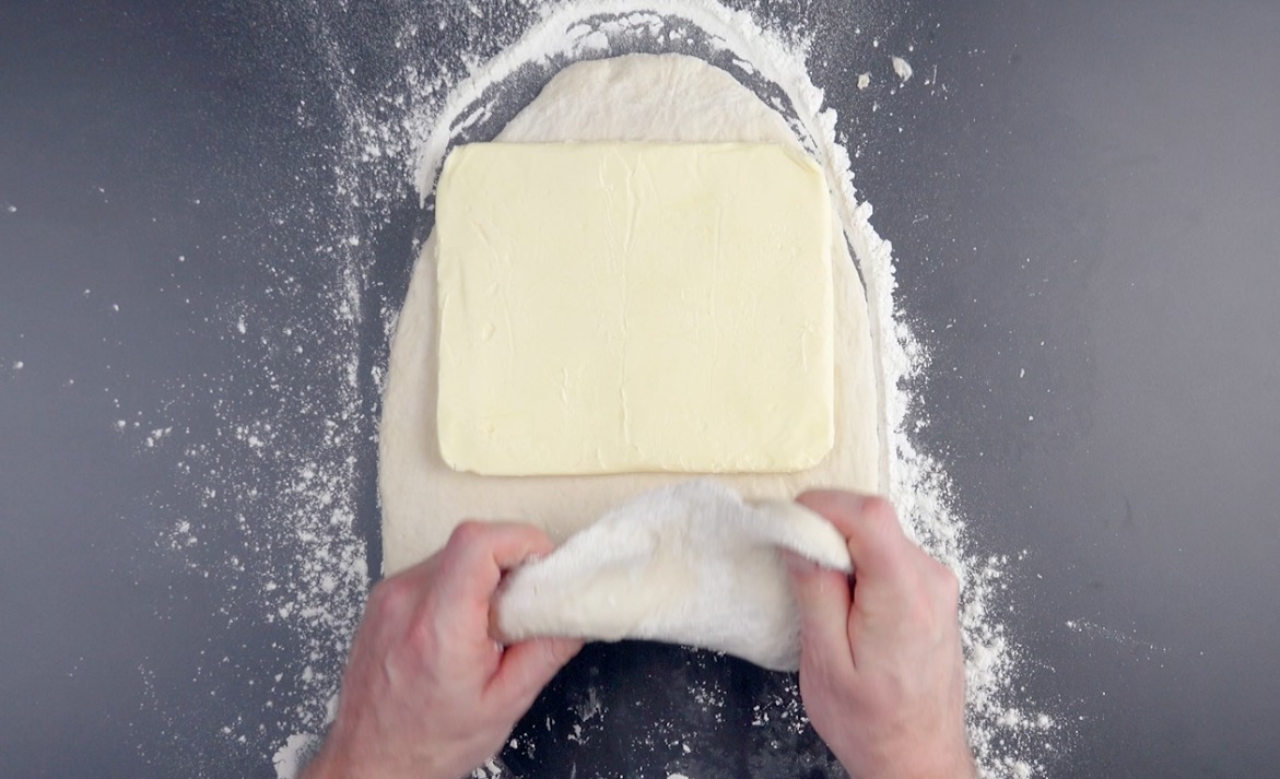 Gewalzte Butter wird auf Teig gelegt und mit Teig bedeckt