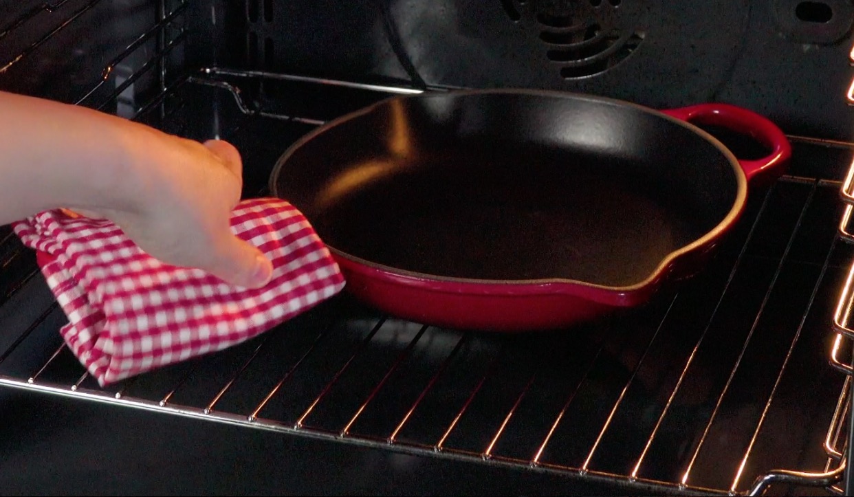 Gusseiserne Pfanne wird in Ofen gestellt