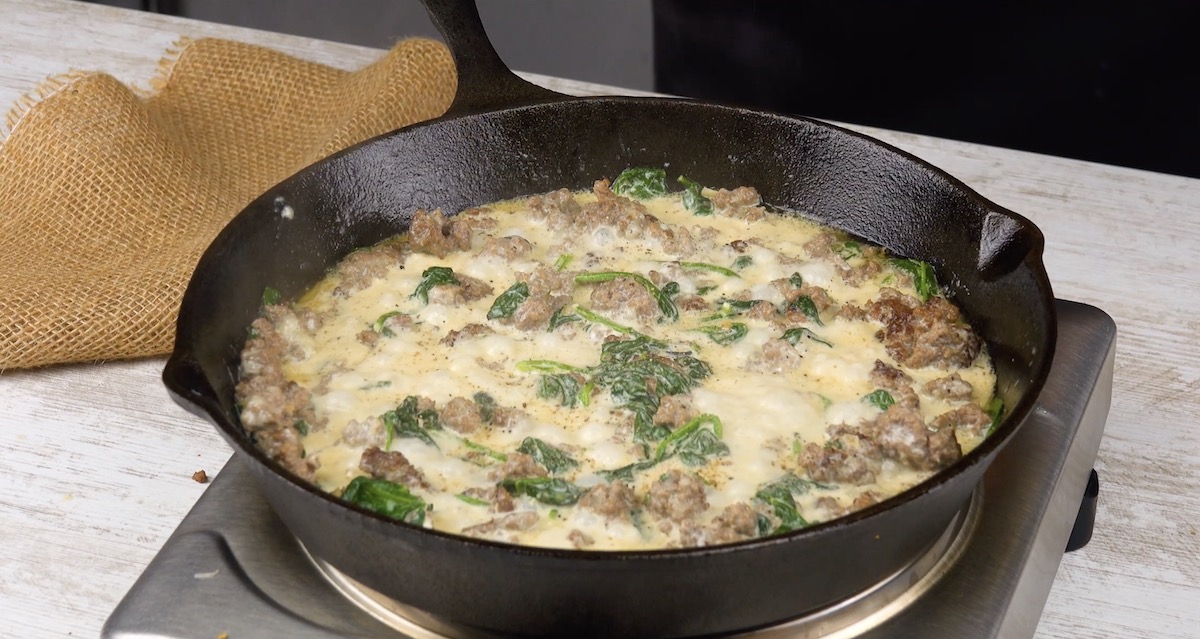 Hackfleisch wird mit Spinat und FrischkÃƒÂ¤se in Pfanne gegart