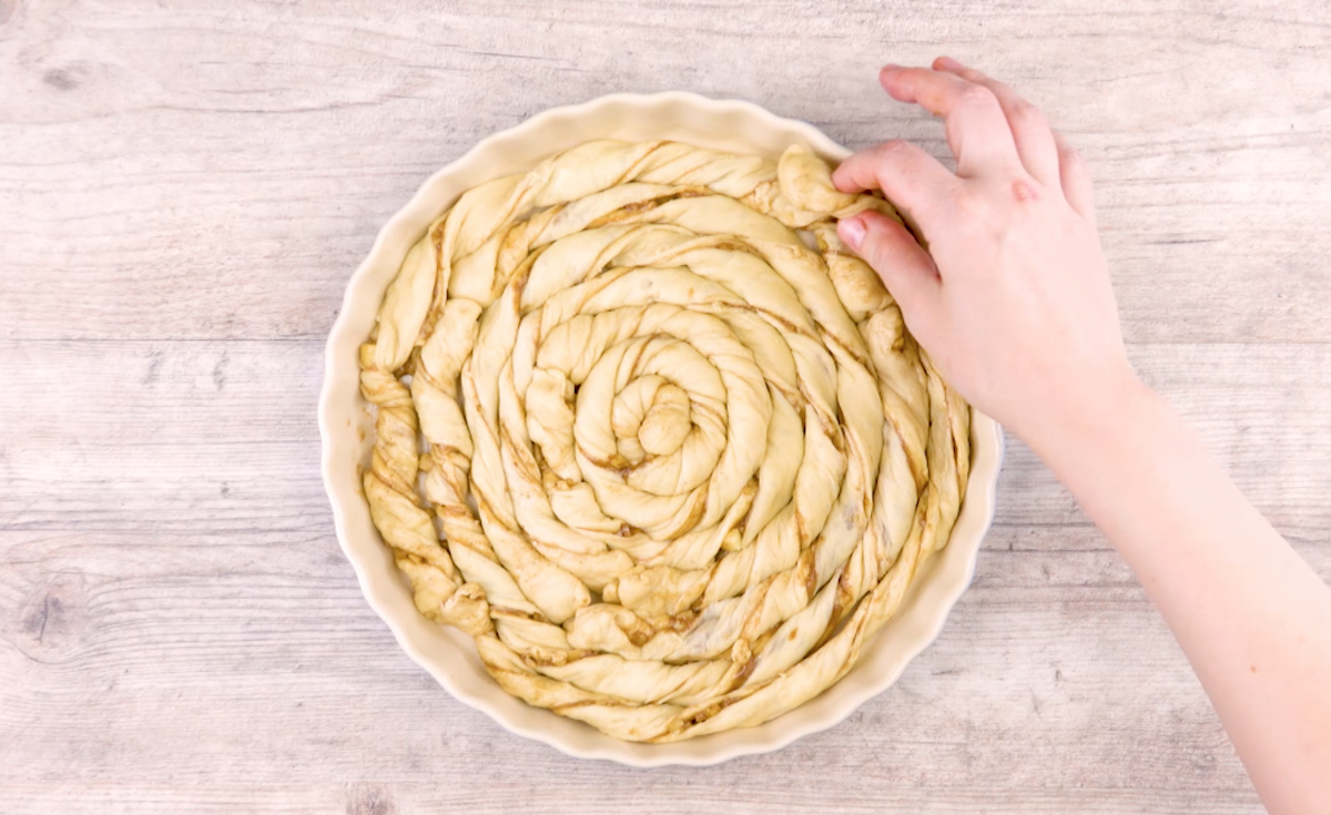 Eine Kuchenform wird mit Teigspiralen ausgelegt