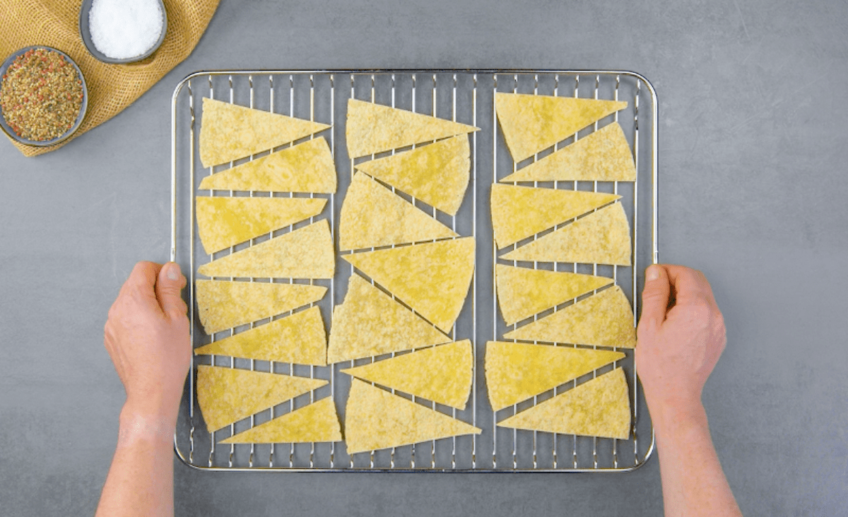 Mehrere Tortilla Dreiecke liegen auf einem Ofenrost