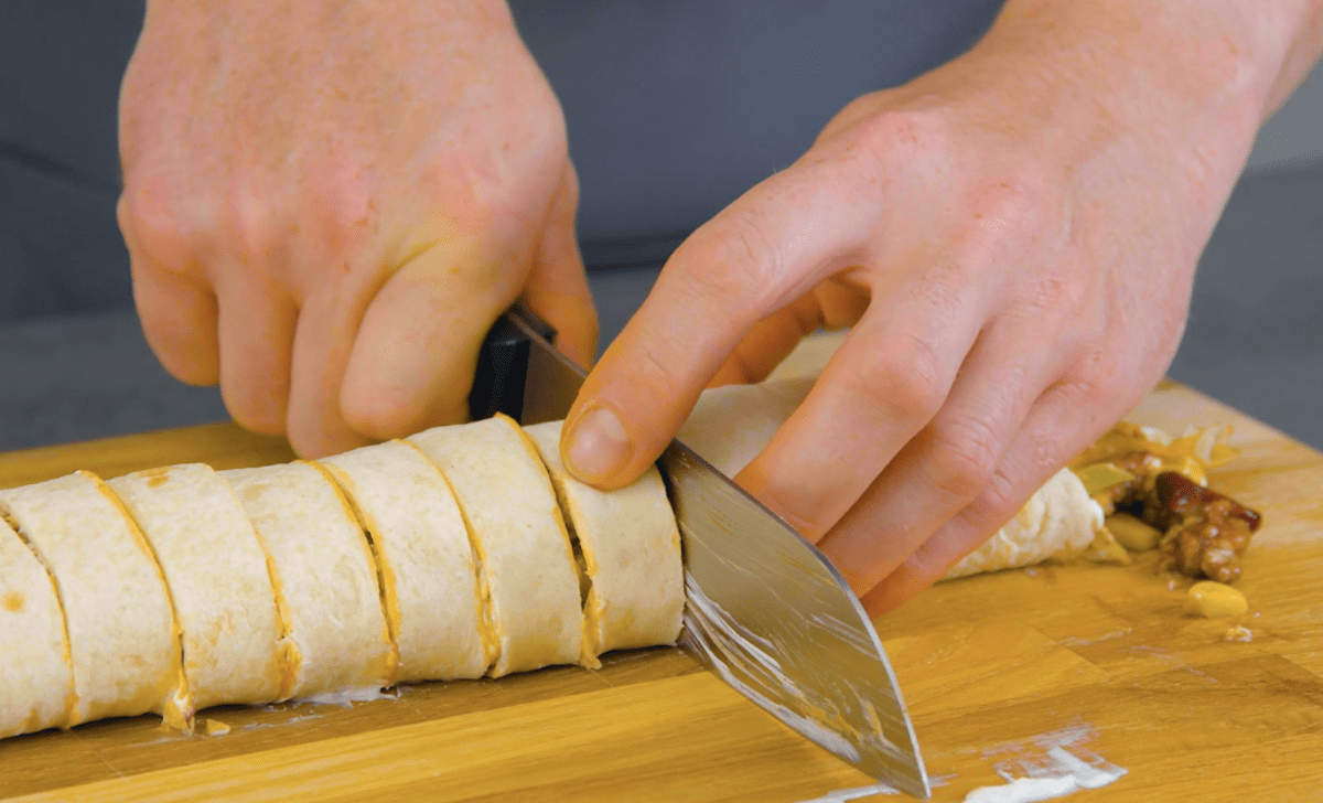 Eine gefÃ¼llte Tortilla Rolle wird in Scheiben geschnitten