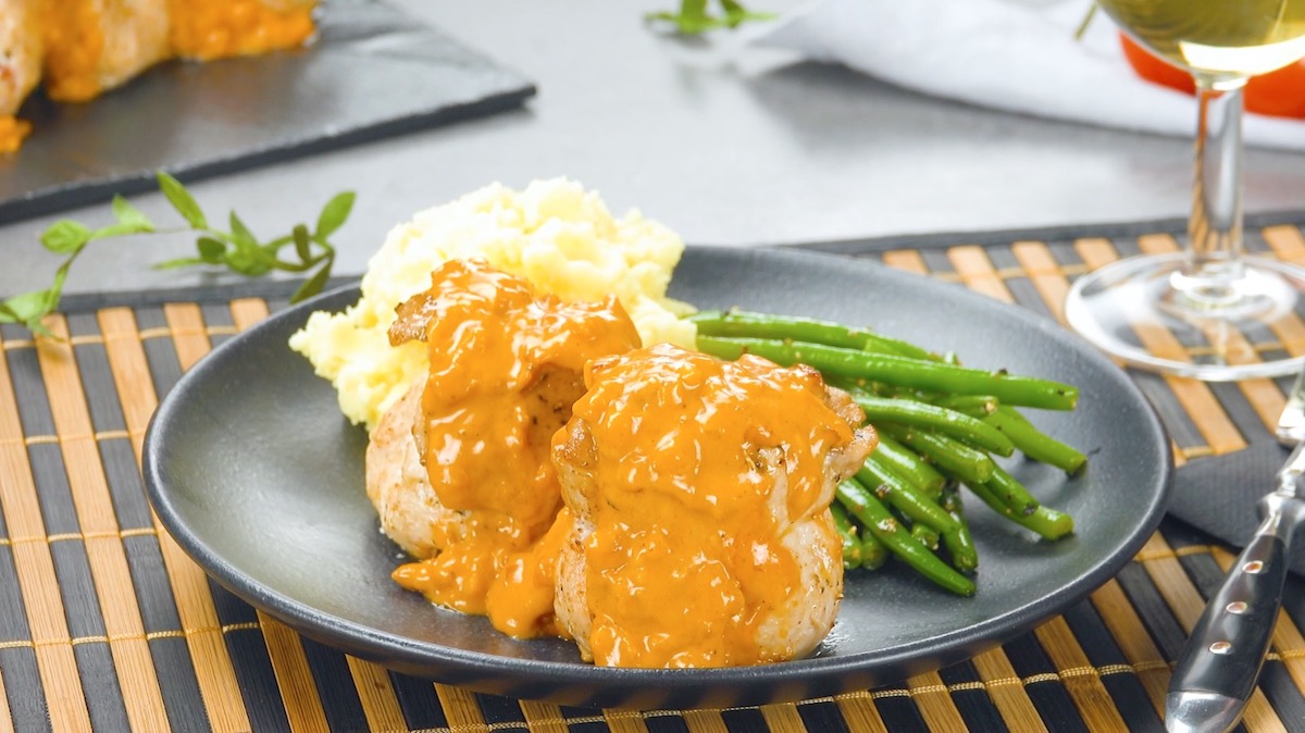 Eine Portion gefüllte Schweineschnitzel mit Kartoffelbrei, Soße und grünen Bohnen