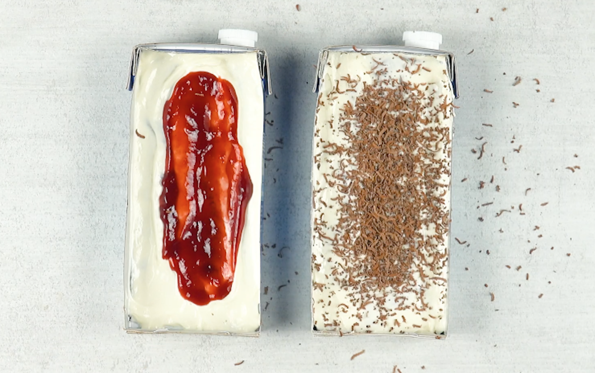 Zwei Milchkartons mit weiÃŸer Creme, der linke mit Marmelade, der rechte mit Schokoraspeln