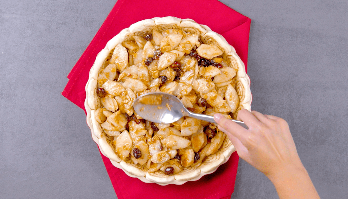 Eine Mischung aus Birnen, Mandelblättchen und Cranberrys wird in eine Kuchenform gegeben