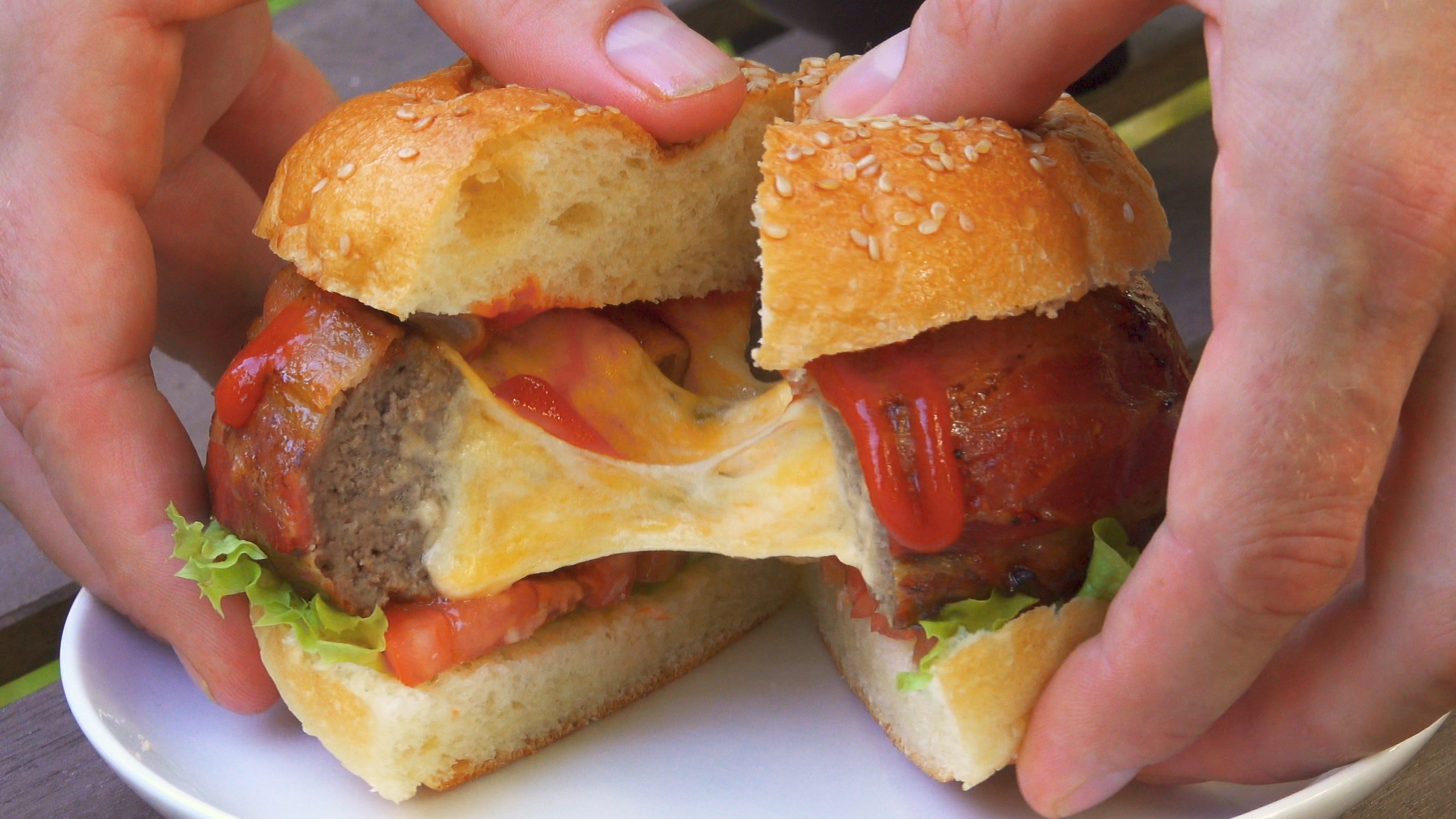 Durchgeschnittener Bierdosen-Burger wird mit HÃ¤nden auseinander gezogen