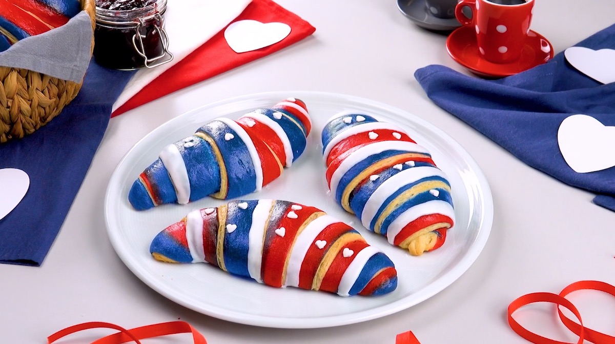 3 bunte Croissants in Tricolore-Optik auf Teller