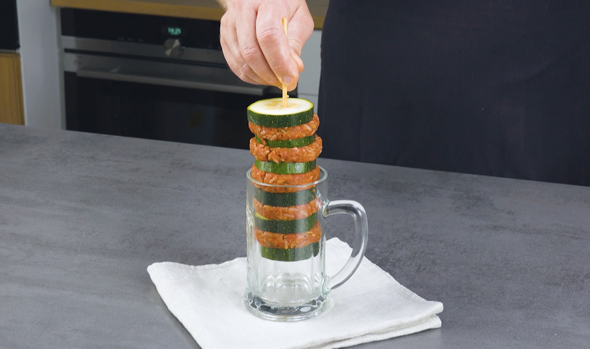 Ein SpieÃŸ wird in mittig ins Glas gespieÃŸt und die Zucchinischeiben samt Hackfleisch dazwischen aus dem Glas geholt
