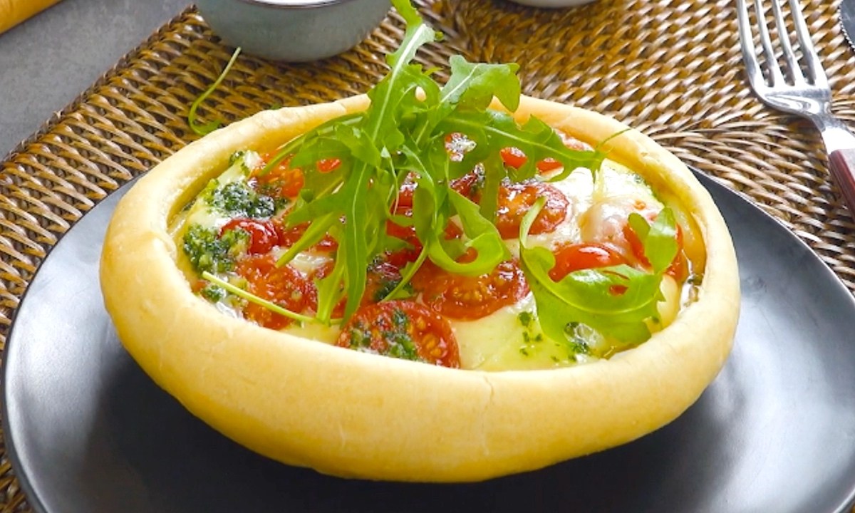 Ein Pizza Pot Pie mit Tomaten-Mozzarella-Füllung und frischem Rucola.