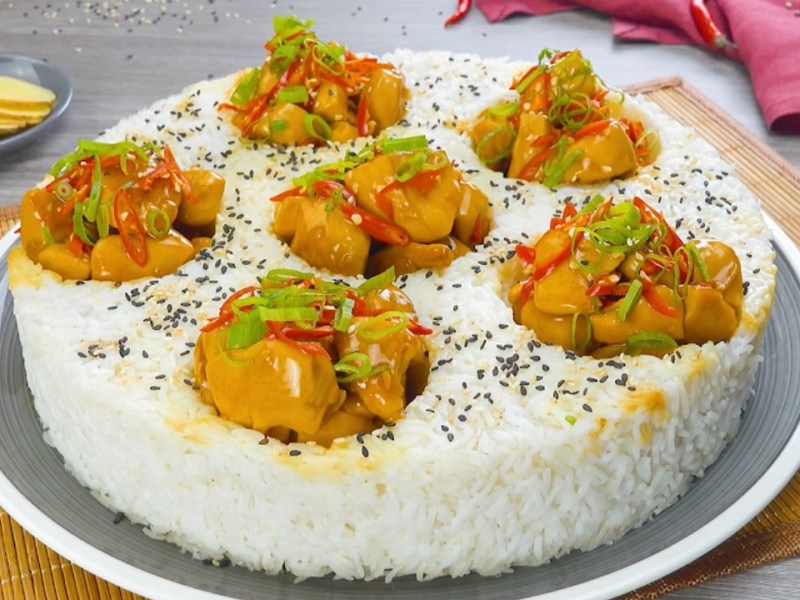 Reiskuchen mit Orangenhähnchen, serviert auf einem Teller.
