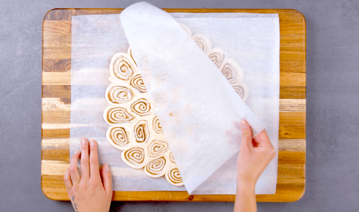 Backpapier wird von platt gerollten Zimtschnecken entfernt