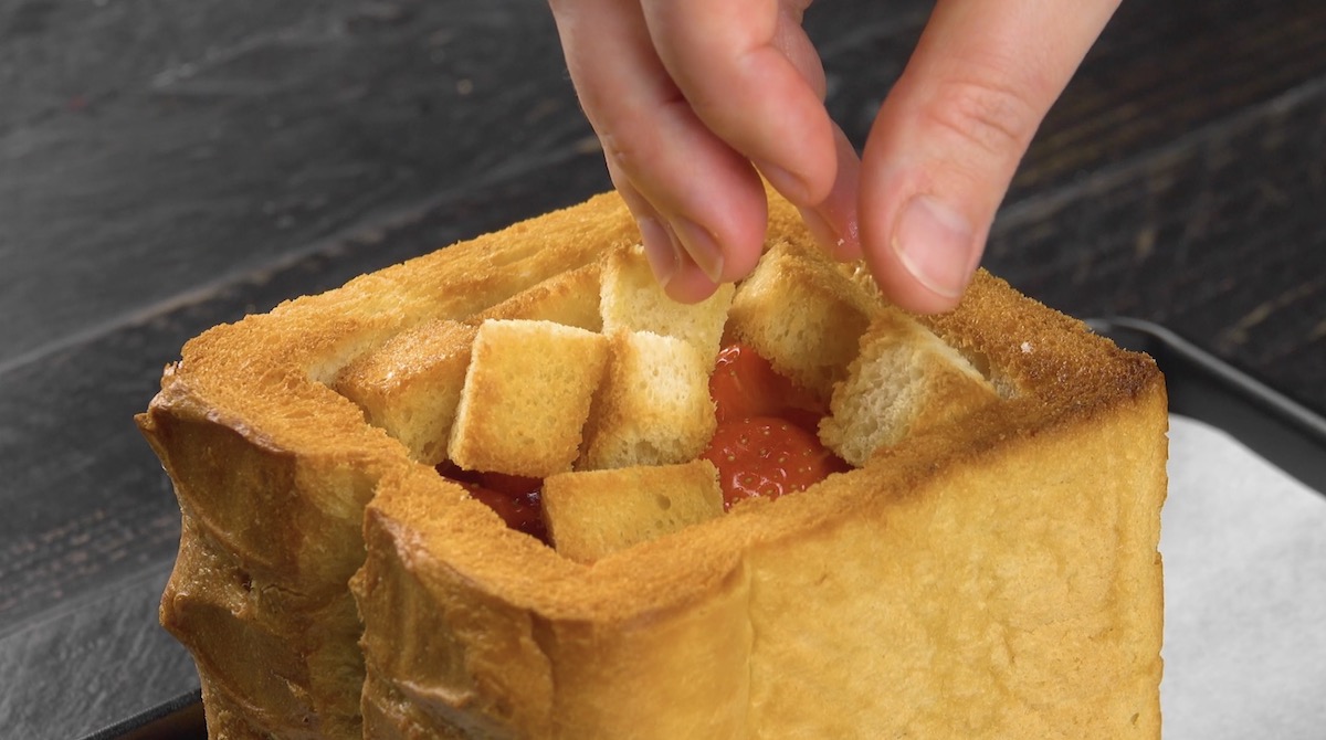 Toast-Quader wird mit ToaststÃ¼cken und Erdbeeren gefÃ¼llt