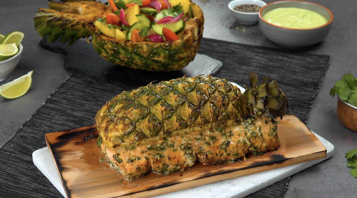 Gegrilltes Lachsfilet mit Ananas und extrarauchigem Aroma auf einem Holzbrett.