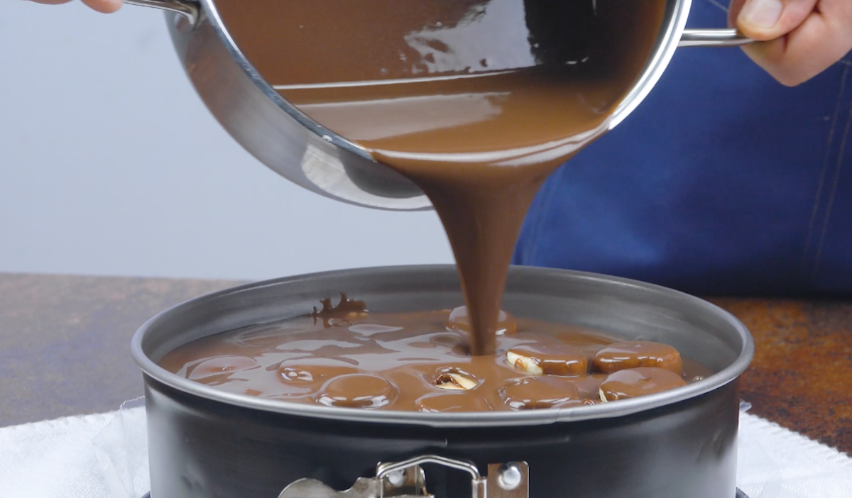 Schokoladenpudding wird Ã¼ber mit Nutella gefÃ¼llte und in einer Springform liegende BananenstÃ¼cke gegossen.