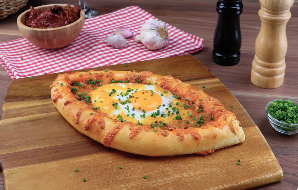 Georgisches Brot mit KÃ¤se und Ei auf Holzbrett