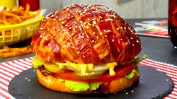 Ein Blumenkohl-Burger mit Bacon-Gitter auf einer runden Schieferplatte.
