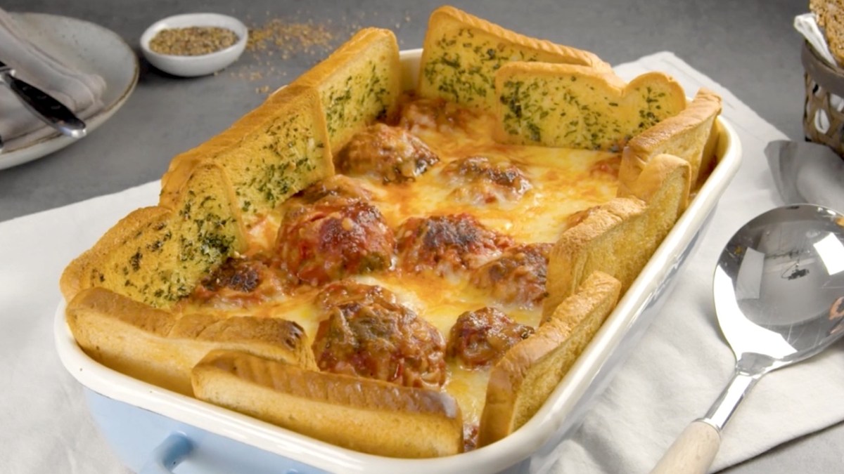 Köstlicher Hackbällchen-Auflauf mit Kräuterbutter-Toast-Zaun in der Auflaufform.