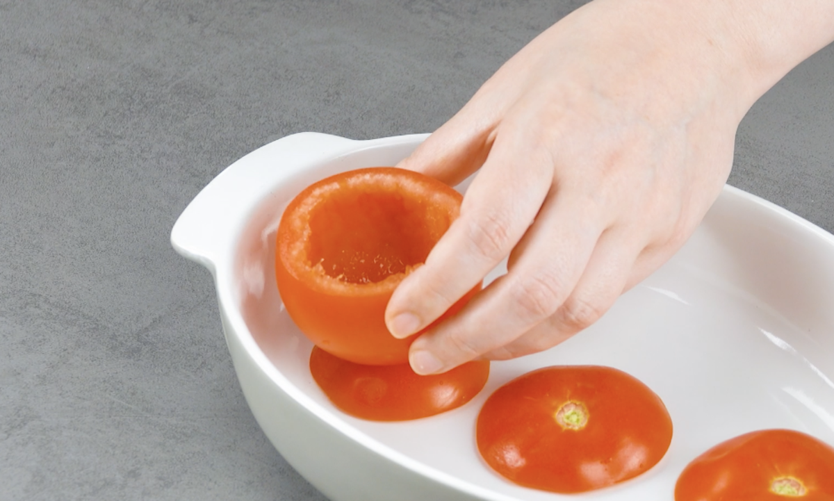 AusgehÃ¶hlte Tomaten werden auf Tomaten-Deckel gestellt