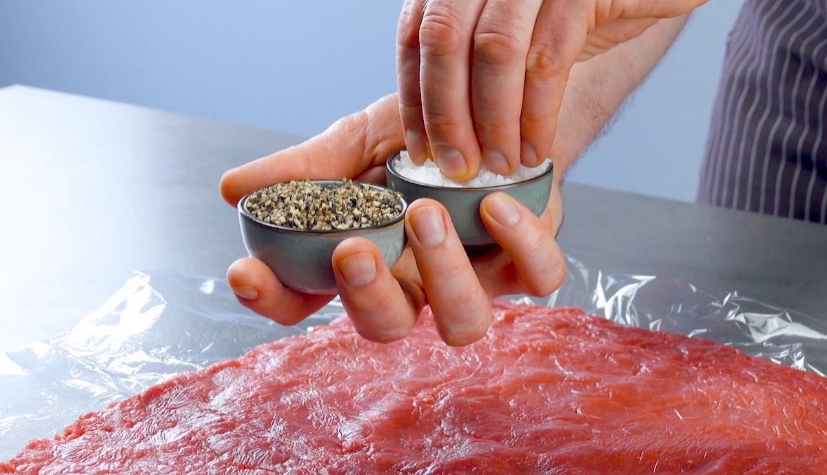 Plattiertes Rinderfilet wird mit Pfeffer und Salz gewürzt