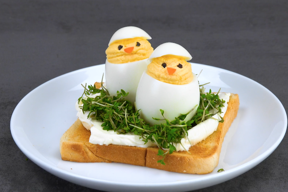 2 HÃ¼hner aus hart gekochten Eier, die auf einem Nest aus Kresse und FrischkÃ¤se auf einem Toast sitzen