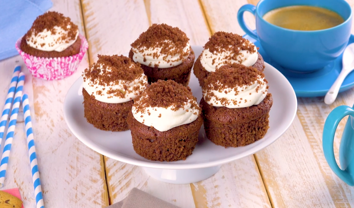5 Maulwurf-Muffins auf einem Teller, daneben ein Muffin auf der einen und eine Tasse Kaffee auf der anderen Seite.