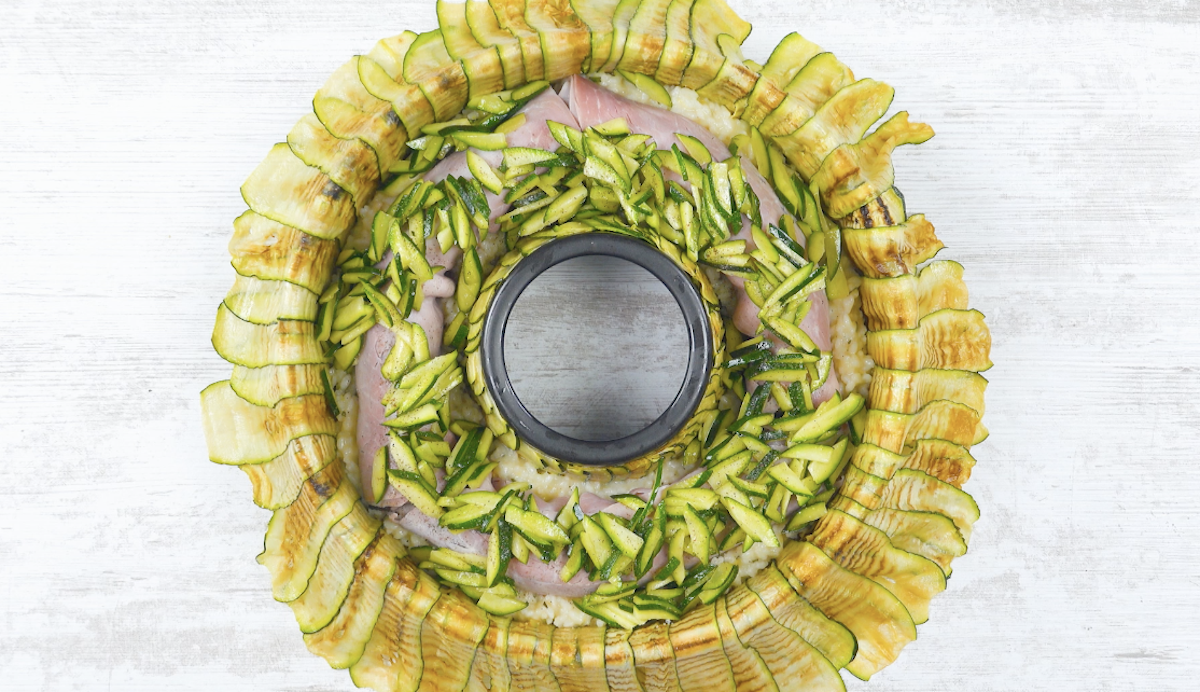 Zucchini-Schnipsel werden auf SchinkenrÃ¶llchen verteilt