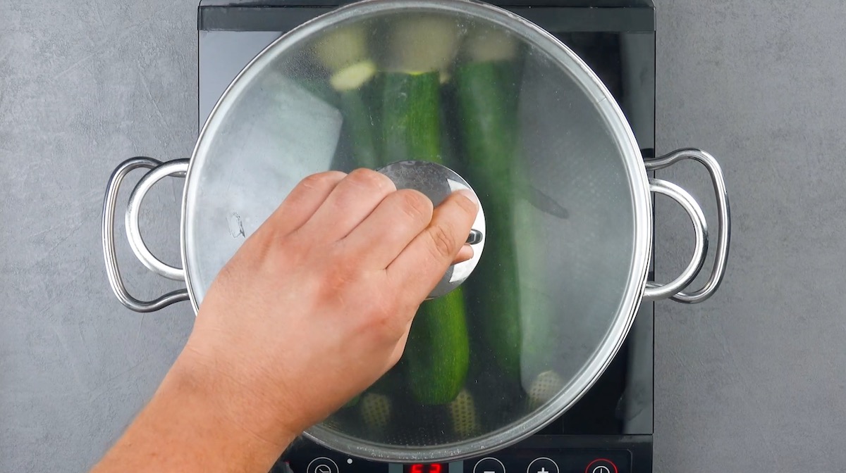 Ganze Zucchini werden in mit Wasser gefÃ¼lltem Topf gegart