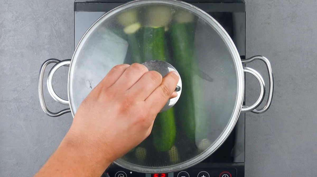 Ganze Zucchini werden in mit Wasser gefülltem Topf gegart