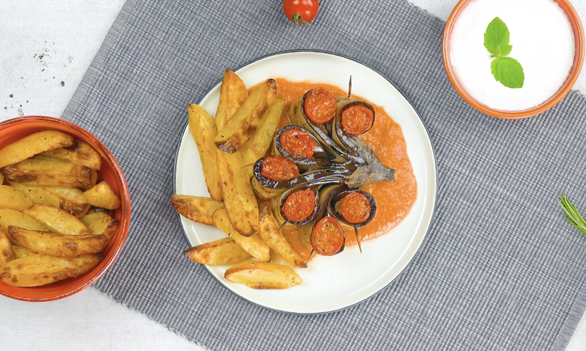 Eine Portion gefÃ¼llte Auberginen mit TomatensoÃŸe und Kartoffelspalten