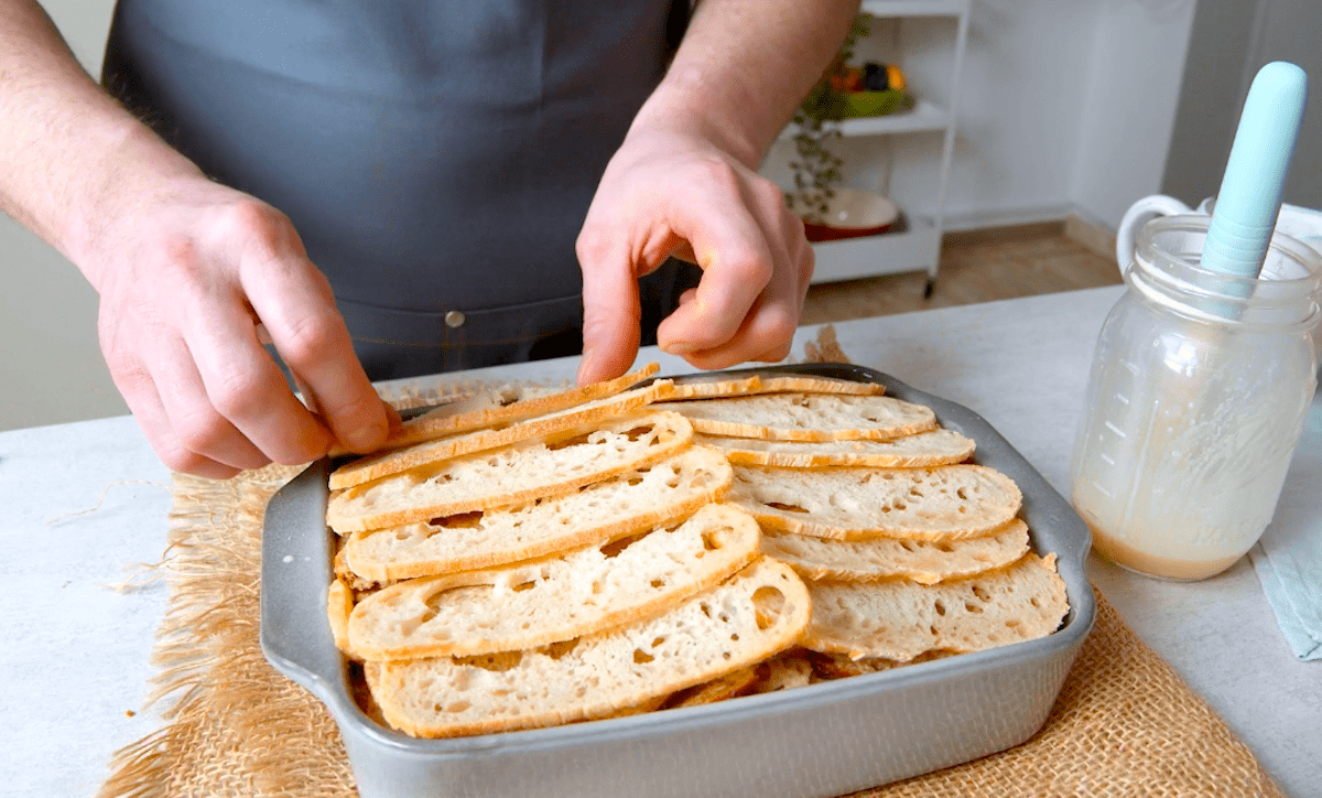 DÃ¼nne Brotscheiben werden in eine Backform gelegt.