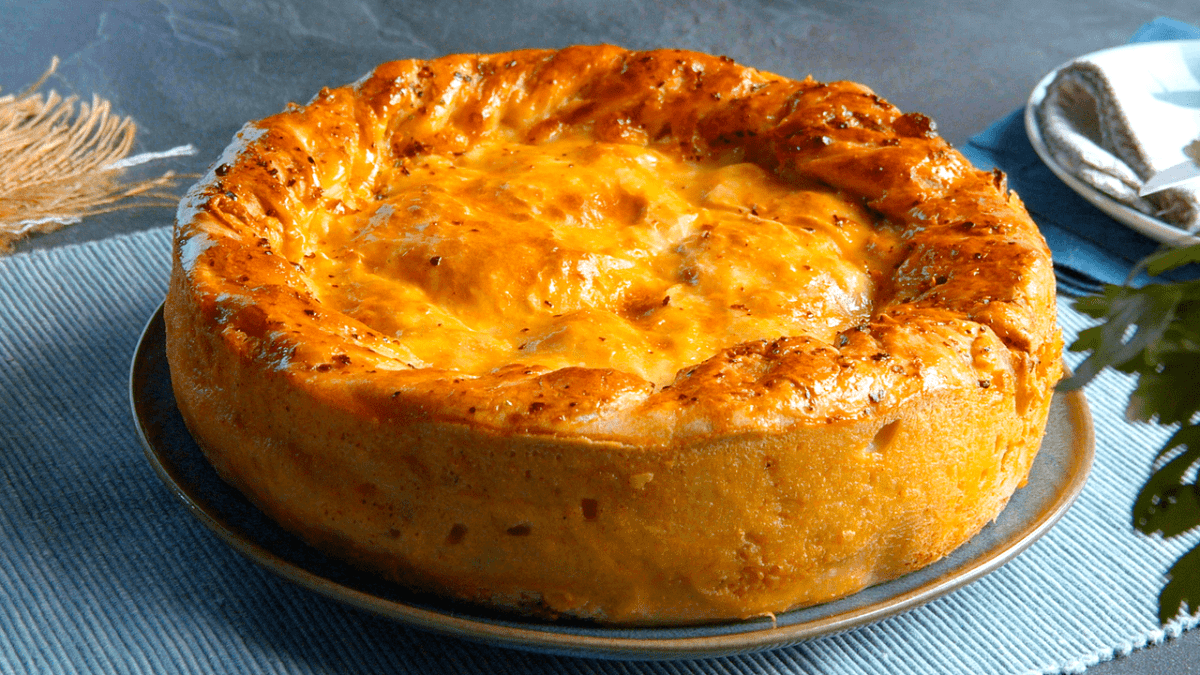 Empanada-Kuchen-mit-Haehnchenbrust-und-Pizzateig auf einer Kuchenform.