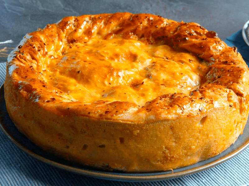 Empanada-Kuchen-mit-Haehnchenbrust-und-Pizzateig auf einer Kuchenform.