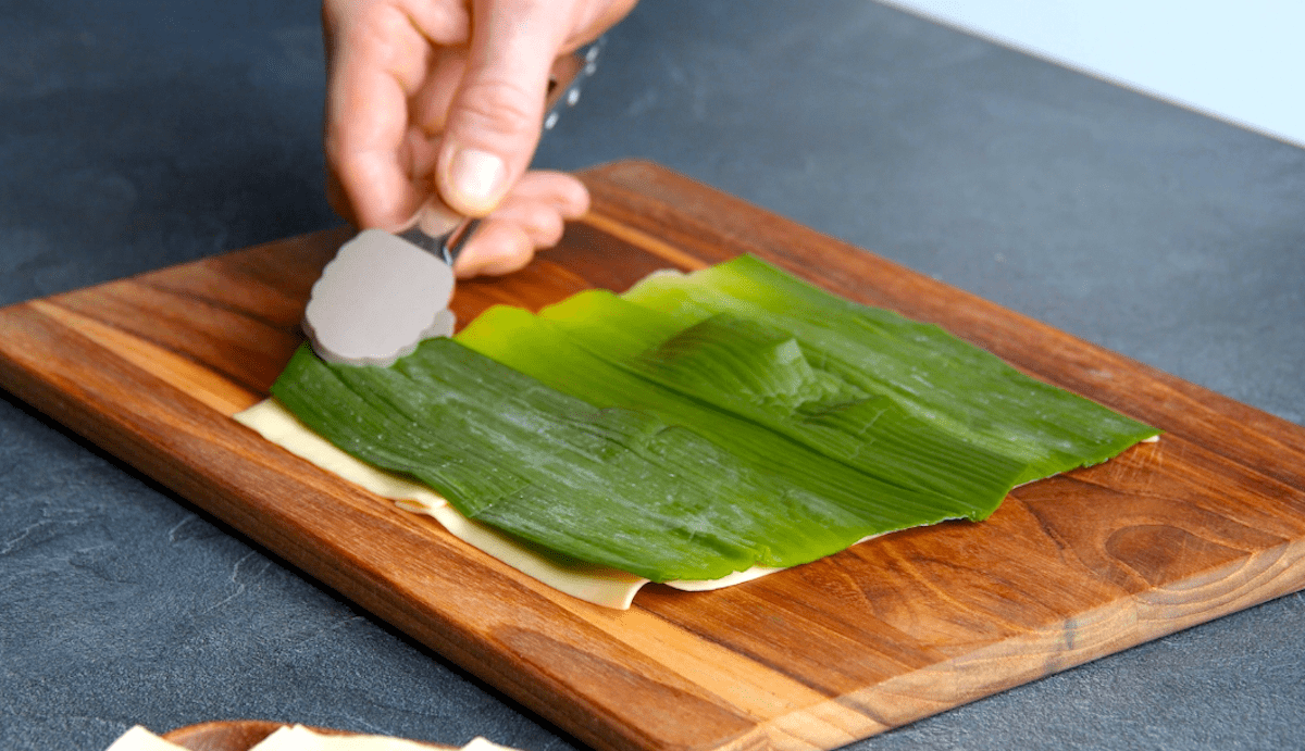 Blanchiertes Lauchgrün wird auf gekochte Lasagneplatten gelegt