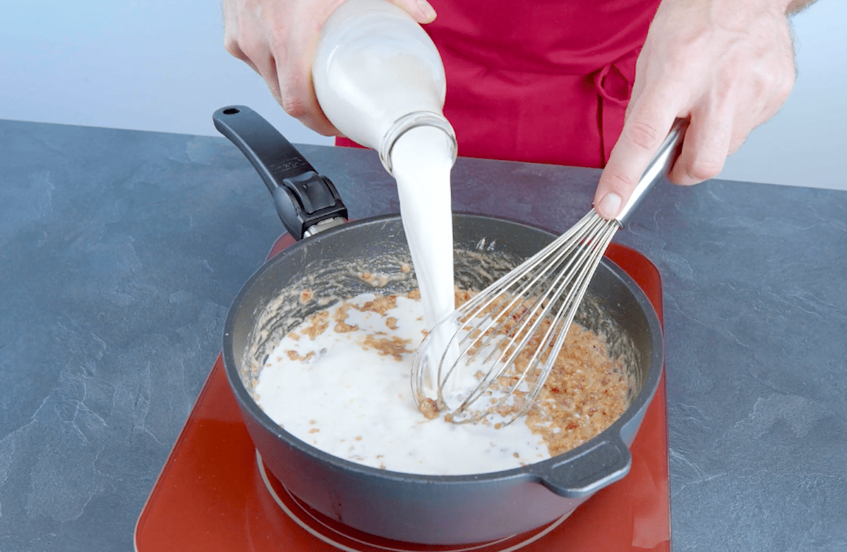 Milch wird zu Serrano Schinken WÃ¼rfel in die Pfanne gegeben