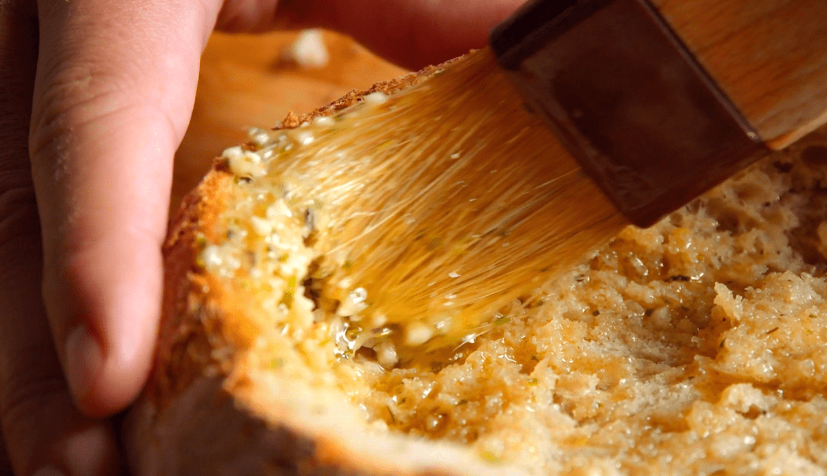 Brot wird mit KrÃ¤uterbutter bestrichen