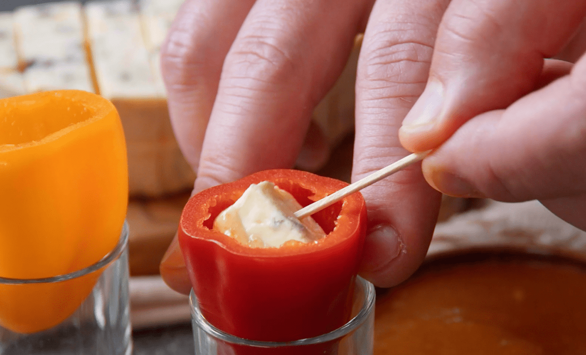 Ein mit Feigensenf verfeinerter Käsewürfel wird in eine Paprika gelegt