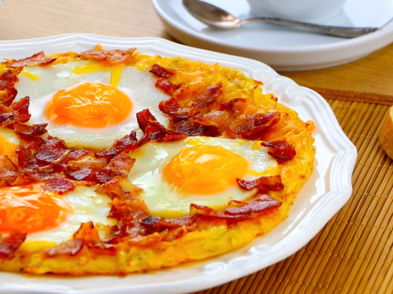 Frühstücks-Rösti mit Ei auf einem Teller, Nahaufnahme.