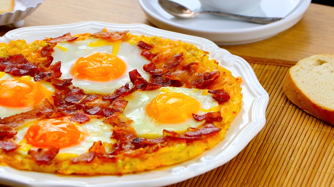 Frühstücks-Rösti mit Ei auf einem Teller, Nahaufnahme.