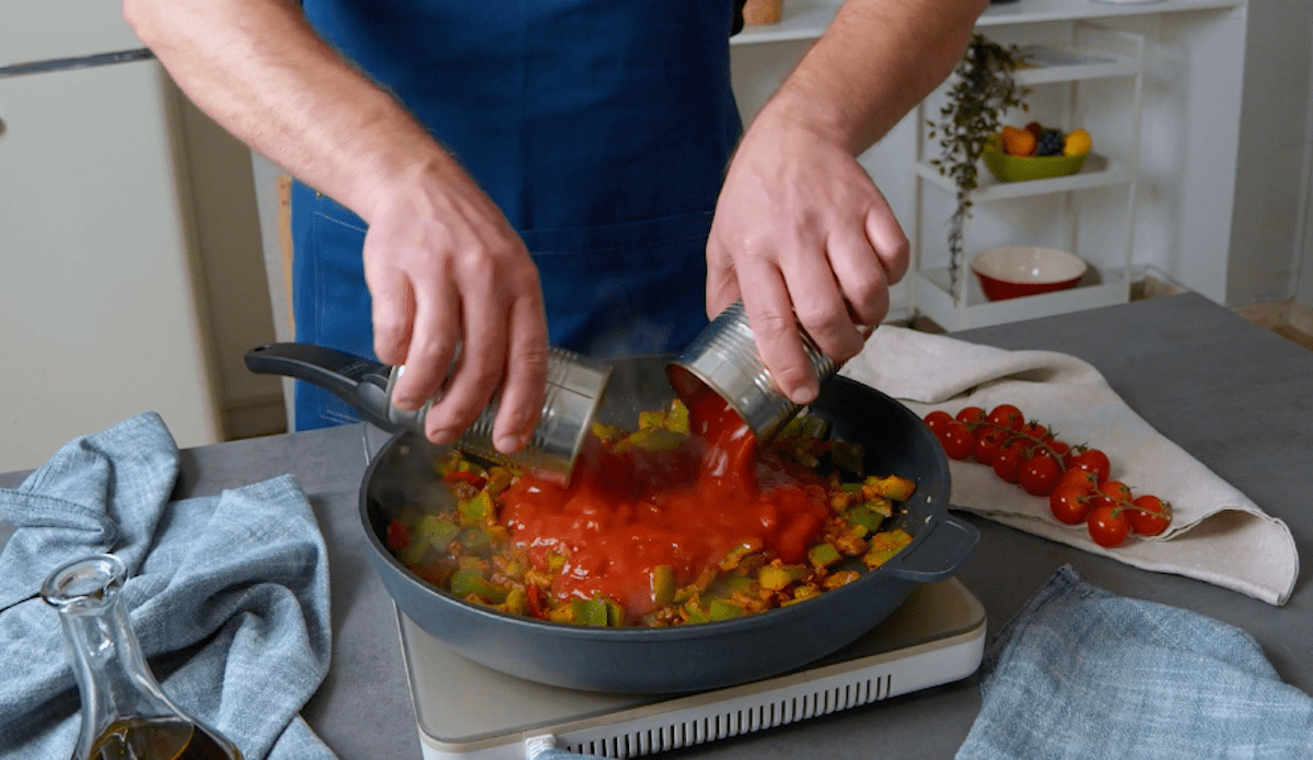 Tomatensauce wird in eine Pfanne gegeben